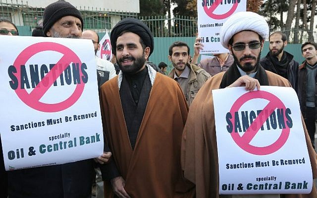 Iranian men hold placards during a demonstration outside the Tehran Research Reactor in the capital Tehran on November 23, 2014 to show their support for Iran's nuclear program. (photo credit: Atta Kenare/AFP)