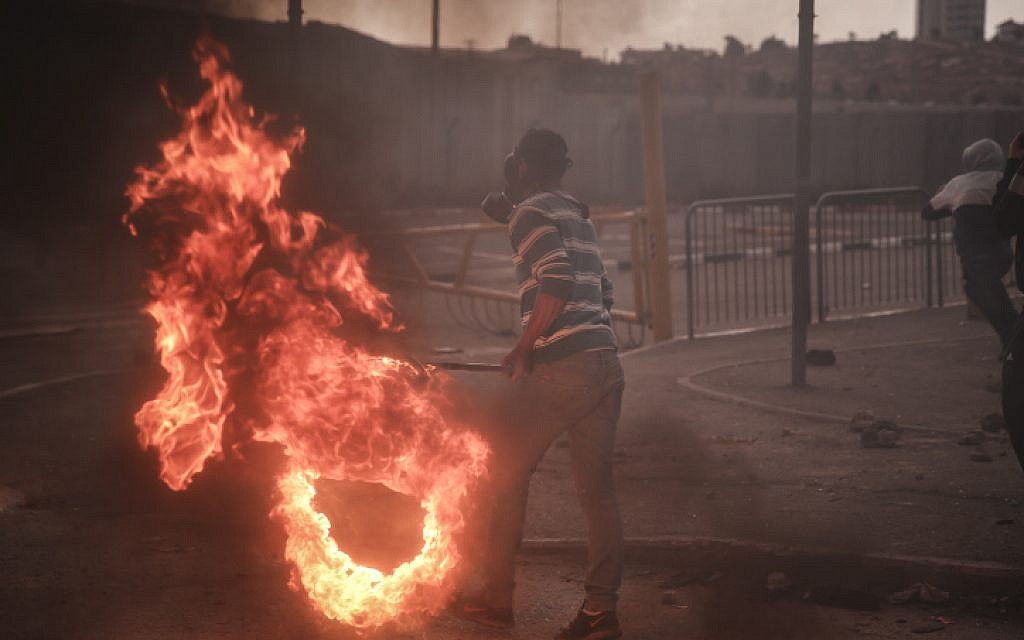 ILLUSTRATIVE: Palestinian youths clash with Israeli Border Police at the entrance to the Shuafat refugee camp on November 5, following a terrorist attack that day in Jerusalem by a resident of the camp. (Hadas Parush/FLASH90)