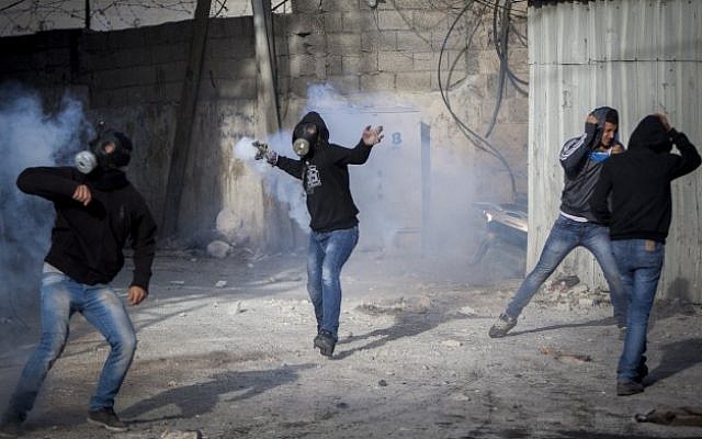 Palestinian youths throw stones during clashes with Israeli Border Police in the Shuafat Refugee Camp, in Jerusalem, following Friday prayers on November 7, 2014. (Photo credit: Yonatan Sindel/Flash90)