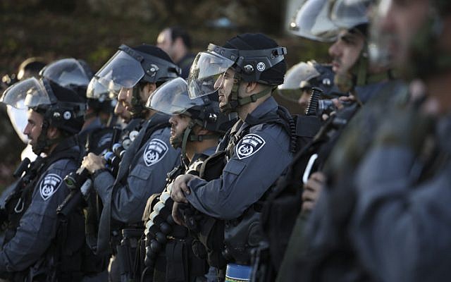 Israeli police officers wait for command to advance towards rioters throwing rocks during clashes at the entrance to the Arab village of Kfar Kanna, in northern Israel, on November 8, 2014. (photo credit: Hadas Parush/Flash90)