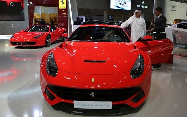 An Emirati visitor talks with a car agent dealer over the Ferrari F12 Berlinetta at the Dubai International Motor Show in Dubai, United Arab Emirates, April 25, 2013 (photo credit: AP/Kamran Jebreili)