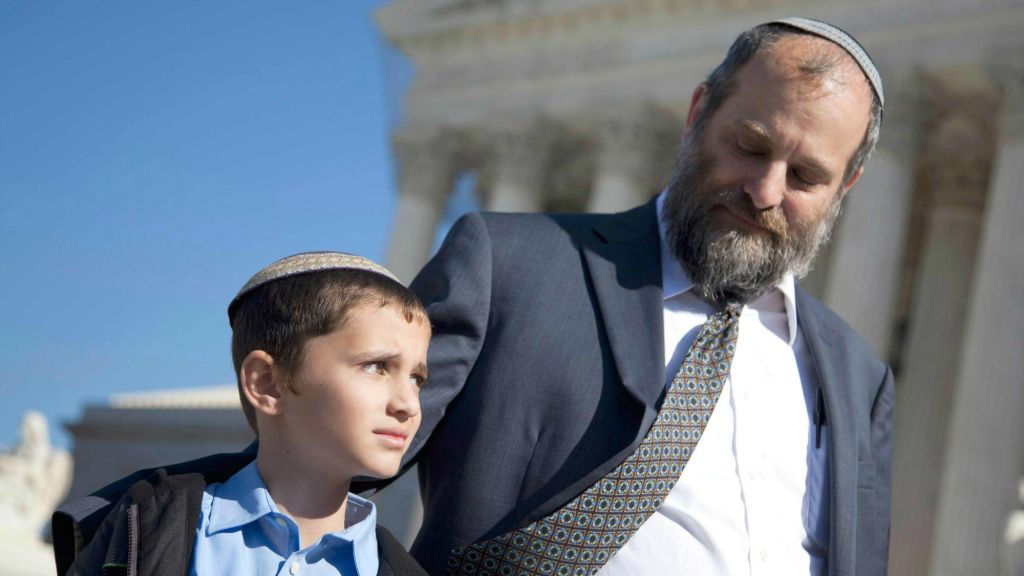 Ari Zivotofsky (right), stands with his nine-year-old son, Menachem, outside the Supreme Court in Washington, DC,  November 7, 2011. (photo credit: AP/Evan Vucci, File)