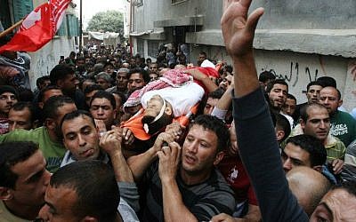 Palestinian mourners carry the body of Imad Jawabrehin, killed in clashes with Israeli security forces, north of the the West Bank city of Hebron November 11,2014 (photo credit: AFP/ Hazem Bader) 