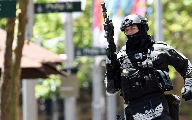 An armed policeman is seen outside a cafe in the central business district of Sydney on December 15, 2014. (Photo credit:AFP/SAEED KHAN)