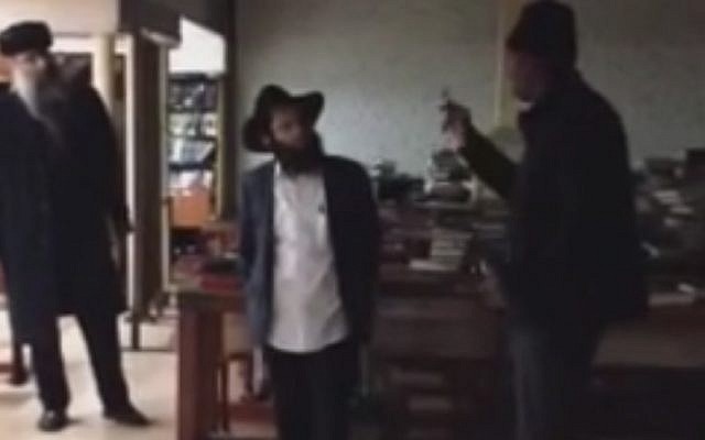 The suspected assailant, right, exchanging words with a Jewish man inside the Chabad headquarters in New York on December 9, 2014. (Screen capture: YouTube)