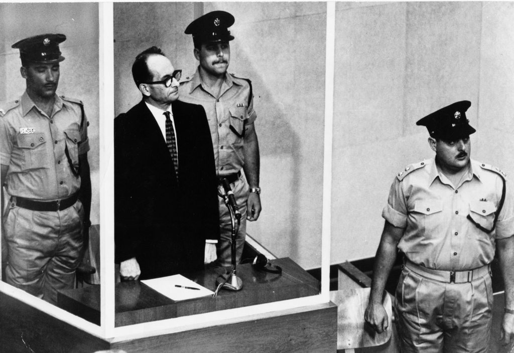 This 1961 file photo shows Adolf Eichmann standing in his glass cage in the Jerusalem courtroom where he was tried and convicted of war crimes committed during World War II. (AP Photo,b/w file)