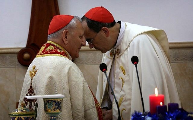 Patriarch of the Chaldean Church, Louis Raphael Sako (L) speaks with Archbishop of Lyon Monseigneur Philippe Barbarin during mass at Saint Marilia church in Erbil, attended by Iraqis who fled the violence in the northern city of Mosul after Islamic State group militants took control of the area, in the capital of the autonomous Kurdish region of northern Iraq, on December 6, 2014. (photo credit: AFP PHOTO / SAFIN HAMED)