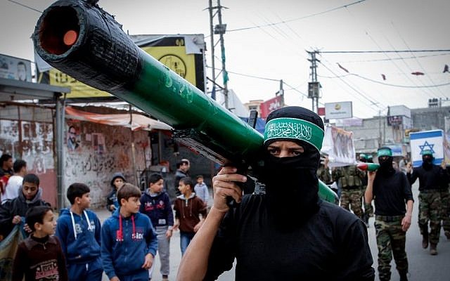 Masked members from the Izz ad-Din al-Qassam Brigades carry a model of a rocket during a rally to commemorate the 27th anniversary of the Islamist movement Hamas at the Nuseirat refugee camp in the Central Gaza Strip, December 12, 2014 (Abed Rahim Khatib/Flash90)