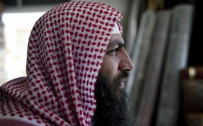 In this photo taken Oct. 29, 2014, Salafi cleric Mohammed al-Shalabi, 48, widely known as Abu Sayyaf, talks during an interview with the Associated Press at a furniture store, owned by the head of Abu Sayyaf's clan, in the city of Ma'an, Jordan. (Photo credit: AP/Nasser Nasser)