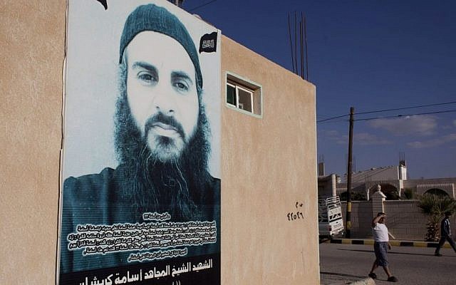 In this photo taken Oct. 27, 2014, a poster with a picture of a late Jordanian Salafi Jihadi, who was killed by Syrian government forces while fighting alongside Jabhat al-Nusra, or al-Nusra Front, an al-Qaida affiliate in Syria, and Arabic that reads "the martyr Jihadi sheikh Osama Kreishan, Abu Abdullah, martyred in Syria Friday, Jan. 3, 2014," is posted on the wall of his family house, in the city of Ma'an, Jordan. (Photo credit: AP/Nasser Nasser)