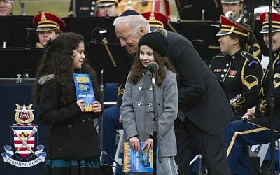 Vice President Joe Biden talks to Basya Fogelman, 9, of Wilkes Barre, Pa, right, and Simmy Hershkop, 11, of Wooster, Ma., left, after they read their winning essays on what Hanukkah means to them as they participate in the annual National Menorah Lighting during a ceremony marking the start of the celebration of Hanukkah, on the Ellipse near the White House in Washington, Tuesday, Dec. 16, 2014. (Photo credit: AP/Cliff Owen)