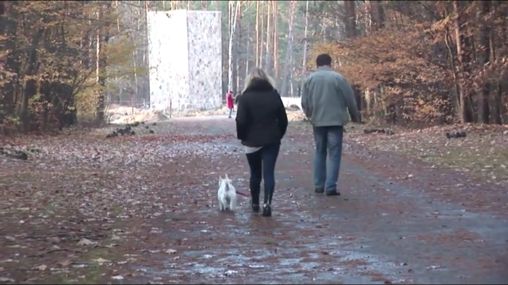 At the former Nazi death camp Sobibor, in eastern Poland, a visitor walks a dog through the area of the recently excavated gas chambers, in this Nov. 11, 2014 photo. (photo credit: Lena Klaudel)