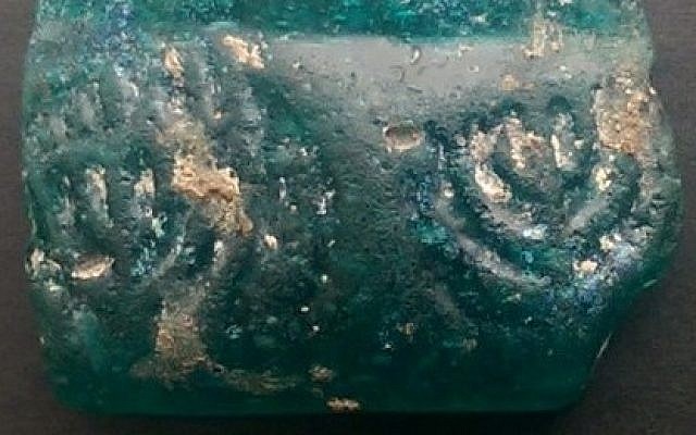 A 1,600-year-old glass shard imprinted with two menorahs, one fully lit (Courtesy: Israel Antiquities Authority)