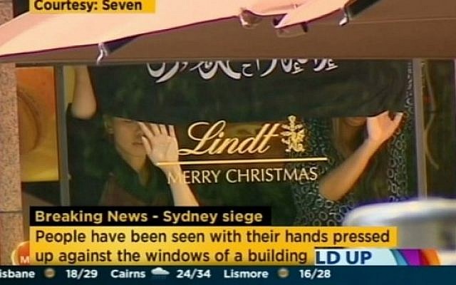 Australian Channel 7 shows the hostages at the Lindt Chocolat Cafe in Sydney, Australia displaying an Islamic flag, December 15, 2014. (Screenshot)