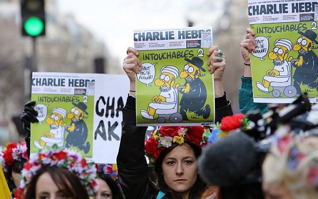 Femen activists hold Charlie Hebdo frontpages during a Unity rally “Marche Republicaine” on January 11, 2015 at the Place de la Republique (Republique's square) in Paris in tribute to the 17 victims of a three-day killing spree by homegrown Islamists. (photo credit: AFP/LOIC VENANCE)