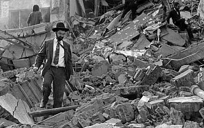 A man walks over the rubble after a bomb exploded at the Argentinian Israelite Mutual Association (AMIA) in Buenos Aires, Argentina, July 18, 1994. (AFP/Ali Burafi)
