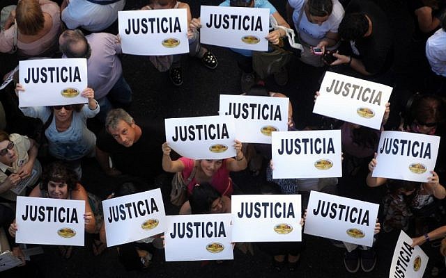 Citizens hold placards that read "Justice" during a rally in front of the headquarters of the AMIA (Argentine Israelite Mutual Association), in Buenos Aires on January 21, 2015.