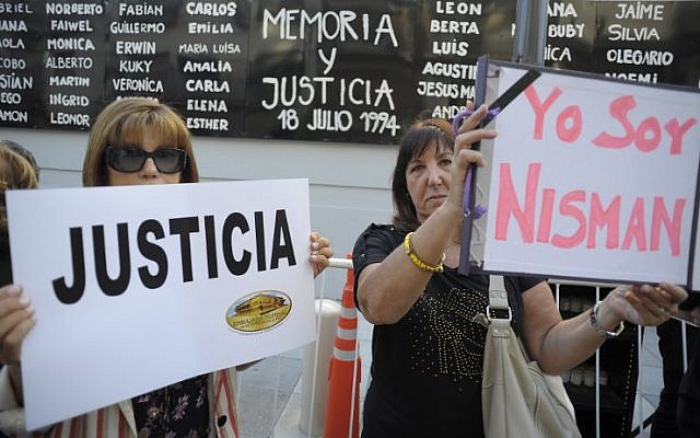 Women hold placards that read "Justice" and "I Am Nisman" during a rally in front of the headquarters of the AMIA memorial in Buenos Aires on January 21, 2015, to protest against the death of Argentine public prosecutor Alberto Nisman. (photo credit: AFP/Alejandro PAGNI)