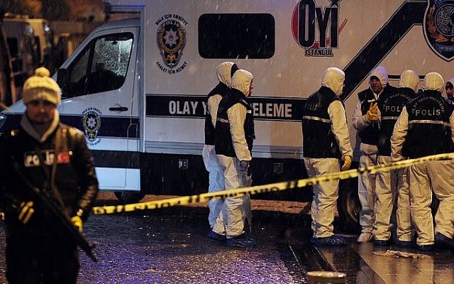 A police officer stands guard while crime scene investigation officers work after a female suicide bomber blew herself up in a police station in the main tourist district of central Istanbul, Turkey, January 6, 2015. (photo credit: AFP/OZAN KOSE) 