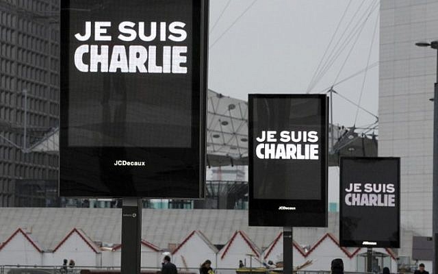 Signs read "Je suis Charlie" (I am Charlie) near La Defense in Paris before the nation observed a minute of silence on January 8, 2015 for the 12 victims of an attack by armed gunmen on the offices of French satirical newspaper Charlie Hebdo in Paris the day before.  (photo credit: AFP/ERIC PIERMONT)