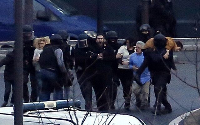 Members of the French police special forces evacuate the hostages after launching the assault at a kosher grocery store in Porte de Vincennes, eastern Paris, on January 9, 2015. (Photo credit: AFP/ THOMAS SAMSON)