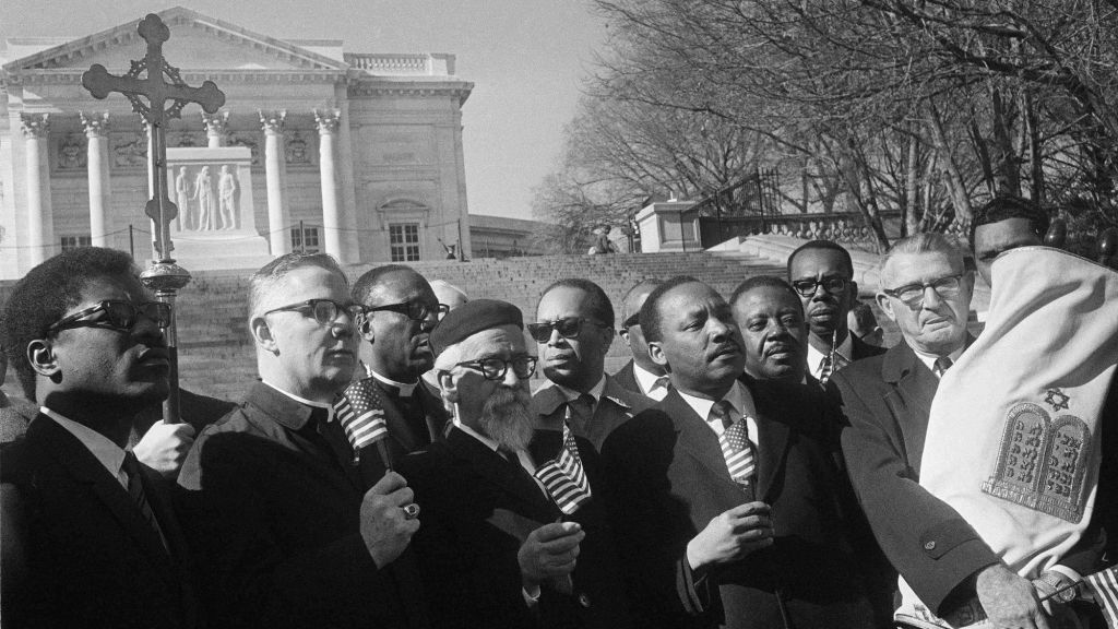 Leaders in a Vietnam war protest stand in silent prayer in Arlington National Cemetery, Feb. 6, 1968. Front row, from left: Rev. Andrew Young, executive vice president of the Southern Christian Leadership Conference; Bishop James P. Shannon, Roman Catholic auxiliary bishop of Minneapolis and St. Paul; Rabbi Abraham Heschel, professor at the Jewish Theological Seminary, New York; the Rev. Dr. Martin Luther King Jr., and Rabbi Maurice Eisendrath, president of the Union of American Hebrew Congregations. The Tomb of the Unknown Soldier and Arlington Amphitheater are in background. (AP Photo/Harvey Georges)