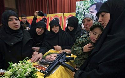 The sister of Hezbollah member Mohammad Issa who was killed in an Israeli airstrike in Syria on Sunday, holds his son Ahmed as she mourns over his coffin during his funeral procession, in the southern village of Arab Salim, Lebanon, Tuesday, Jan. 20, 2015 (photo credit: AP/Mohammed Zaatari)
