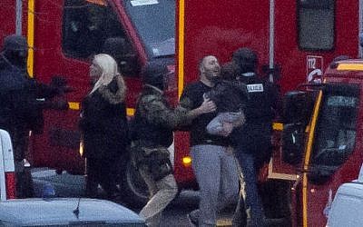 A security officer directs released hostages after French security forces stormed a kosher market to end a hostage situation, Paris, Friday, Jan. 9, 2015.  (Photo credit: AP/Michel Euler)