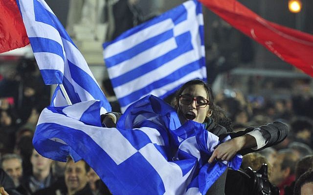 A woman waves a Greek flag during a speech by Alexis Tsipras, the leader of the newly elected Syriza party outside Athens University Headquarters, Jan. 25, 2015. (AP Photo/Fotis Plegas G.)