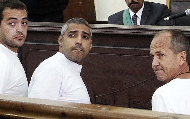 Al-Jazeera English producer Baher Mohamed (left), Canadian-Egyptian acting Cairo bureau chief Mohamed Fahmy (center), and correspondent Peter Greste (right), appear in court along with several other defendants during their trial on terror charges, in Cairo, Egypt, March 31, 2014. (photo credit: AP/Heba Elkholy, el Shorouk, File)
