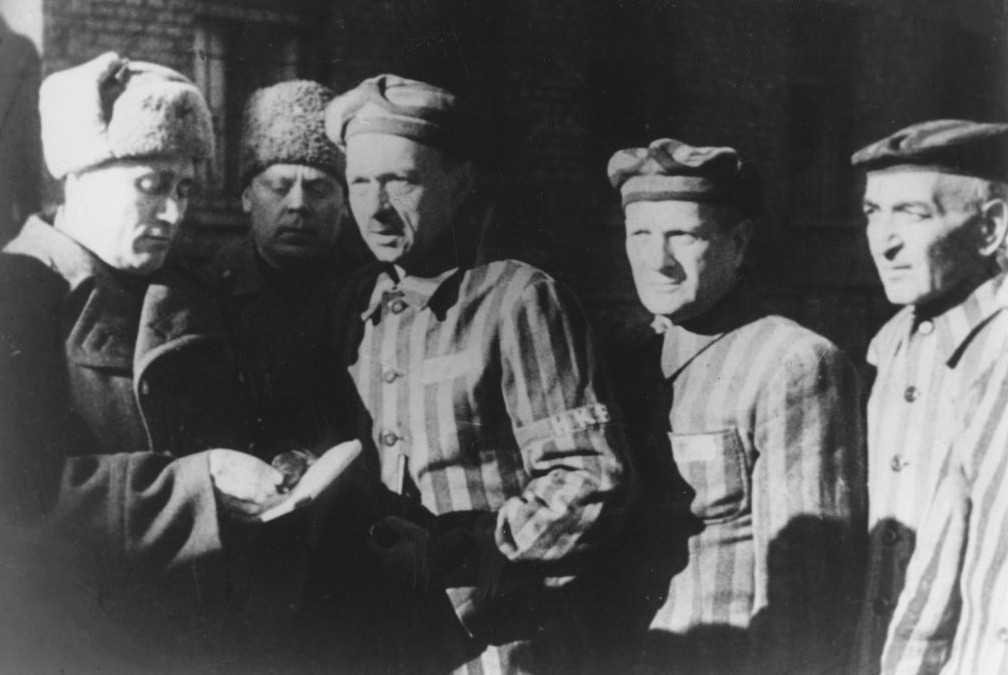 In this file photo dated January 1945, three Auschwitz prisoners, right, talk with Soviet soldiers after the Nazi concentration camp Auschwitz, in Poland, was liberated by the Russians. (Photo credit: AP/FILE)