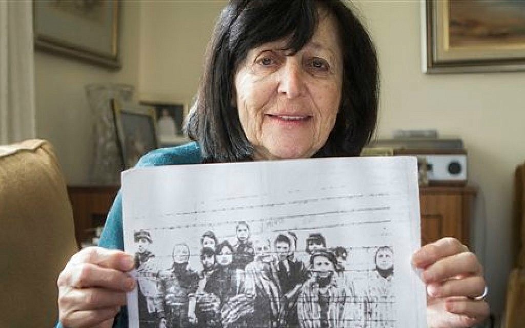 In this photo taken Thursday, Jan. 22, 2015, Marta Wise holds a famous black-and-white photo, taken by the Russian liberators of Auschwitz, showing her, center, with about a dozen children in rags standing behind a row of barbed wire (photo credit: AP/Dan Balilty)