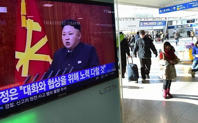 File: Travelers walk past a television screen showing North Korean leader Kim Jong Un's New Year speech, at a railroad station in Seoul on January 1, 2015. (AFP/Jung Yeon-Je)