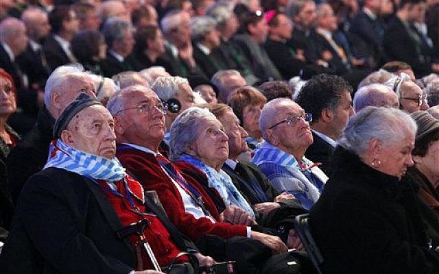 Holocaust survivors watch suspended screens in a tent raised at the entrance of the Birkenau Nazi death camp in Oswiecim, Poland, Tuesday, Jan. 27, 2015, during the official remembrance ceremony. (photo credit: AP Photo//Czarek Sokolowski)