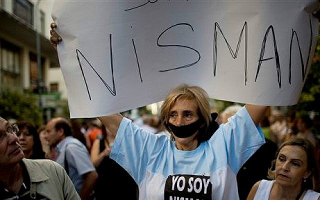 A woman with her mouth taped shut, holds a sign that reads in Spanish; 'I am Nisman' outside the AMIA Jewish community center, in Buenos Aires, Argentina, Wednesday, January 21, 2015 (photo credit: AP/Rodrigo Abd)