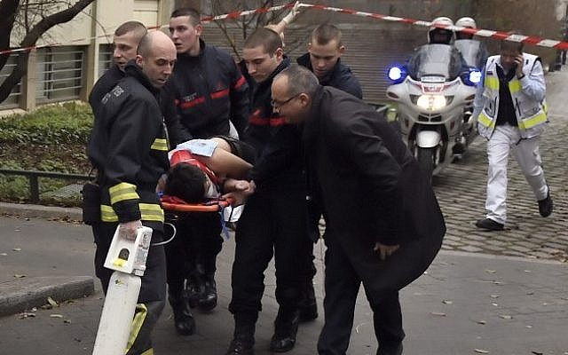 A victim is evacuated on a stretcher on January 7, 2015 after armed gunmen stormed the offices of the French satirical newspaper Charlie Hebdo in Paris, leaving 12 people dead. (Photo credit: AFP/ MARTIN BUREAU)