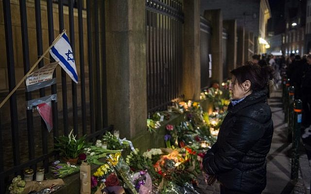 Well wishers reacts as they bring flowers and light candles to honor the shooting victims outside the main Synagogue in Copenhagen, Denmark on February 15, 2015 (photo credit: AFP/Odd Andersen)