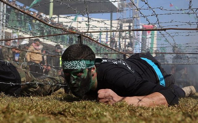 Illustrative photo of a Palestinian youth crawling under a barbed wire obstacle during a graduation ceremony for a training camp run by the Hamas movement on January 29, 2015 in Khan Yunis, in the southern Gaza Strip. (AFP photo/Said Khatib)