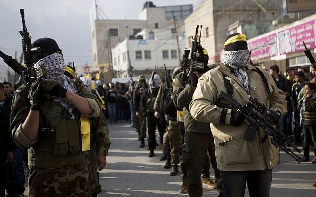 Palestinian gunmen of Fatah's al-Aqsa Martyrs' Brigades march during a military parade to mark the 50th anniversary of the Fatah movement in the Qalandia refugee camp near the West Bank city of Ramallah, Thursday, Jan. 1, 2015. (photo credit: AP Photo/Majdi Mohammed)