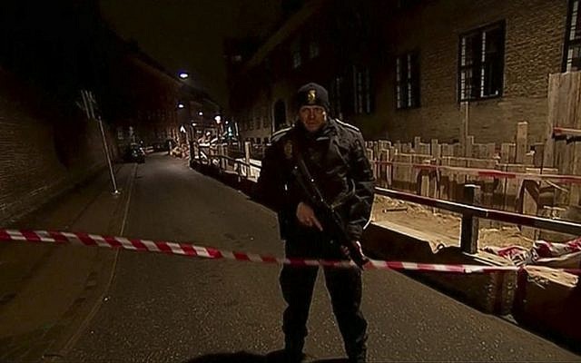 This image made from TV2 via Associated Press News video shows armed police guard behind police tape near a synagogue where police reported a shooting in downtown Copenhagen, Denmark, Sunday, Feb. 15, 2015. One person was shot in the head and two police officers were shot in the arms and legs, police said. (photo credit: AP Photo/TV2 via APTN)