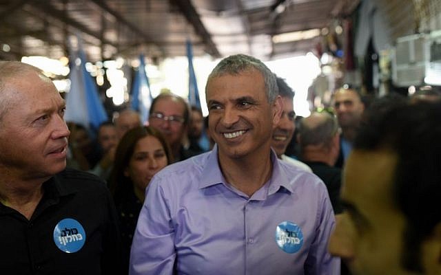 Kulanu party leader Moshe Kahlon walks with party members during a campaign stop at the Carmel market in Tel Aviv, February 4, 2015 (Ben Kelmer/FLASH90)