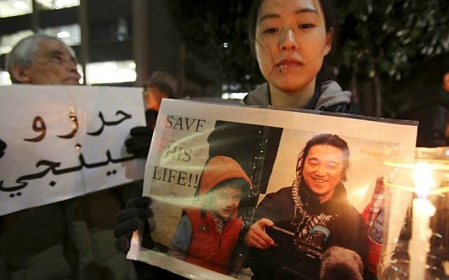In this Friday, Jan. 30, 2015 file photo, a protester holding a photo of Japanese journalist Kenji Goto, who was taken hostage by the Islamic State group, appeals to the government to save Goto during a rally in front of the prime minister's official residence in Tokyo. (AP Photo/Koji Sasahara, File)