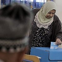 Illustrative: An Arab Israeli woman casts her vote at a polling station in the coastal city of Haifa, on March 17, 2015. (AFP/Ahmad Gharabli)