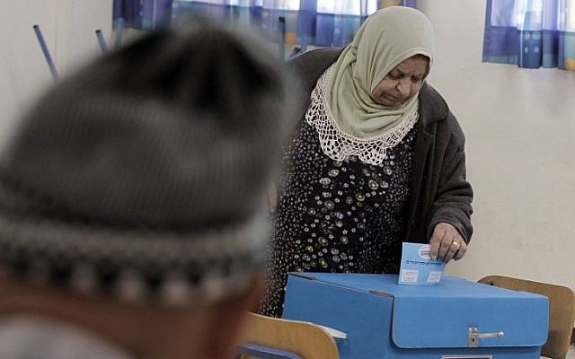 Illustrative: An Arab Israeli woman casts her vote at a polling station in the coastal city of Haifa, on March 17, 2015. (AFP/Ahmad Gharabli)