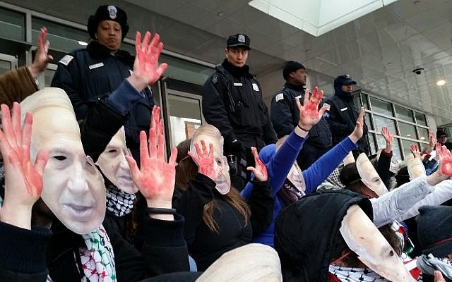 Anti-Israel demonstrators wearing masks bearing the likeness of Israeli Prime Minister Benjamin Netanyahu and holding up "bloody" hands protest March 1, 2015 outside the Washington Convention Center, host to the American Israel Public Affairs Committee (AIPAC) annual policy conference. (photo credit: AFP/MICHAEL MATHES)