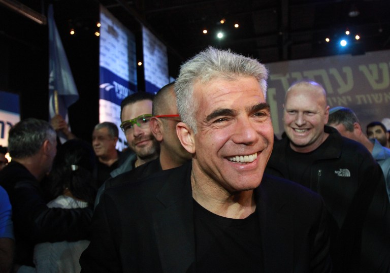 Israeli MP and chairperson of the centrist Yesh Atid party, Yair Lapid celebrates with supporters early on January 18, 2015 at his party headquarters in Tel Aviv. (photo credit: AFP / GIL COHEN-MAGEN)