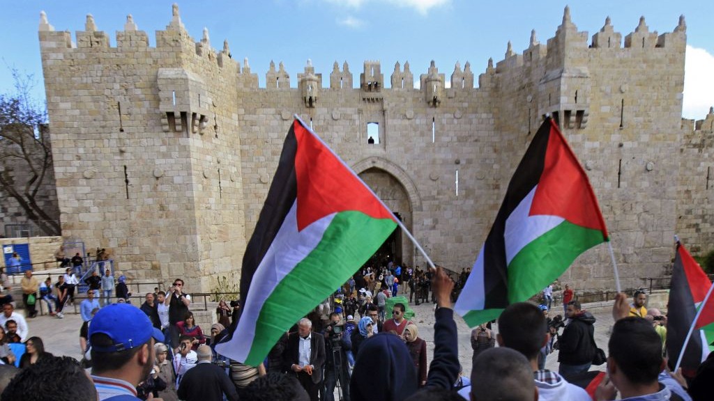 Palestinians carry national flags during a protest marking Land Day in front of the Damascus Gate in Jerusalem's Old City, Monday, March 30, 2015 photo credit: AP/Mahmoud Illean