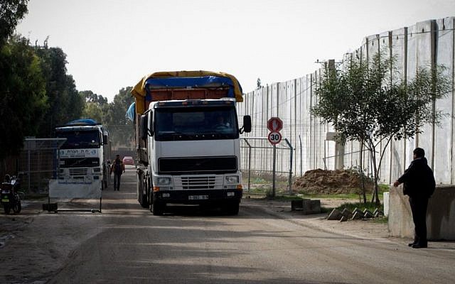 A Palestinian policeman stands near trucks loaded with cement that entered the Gaza Strip from Israel through the Kerem Shalom crossing in Rafah in the southern Gaza Strip on November 25, 2014. (Photo credit: Abed Rahim Khatib / Flash90)
