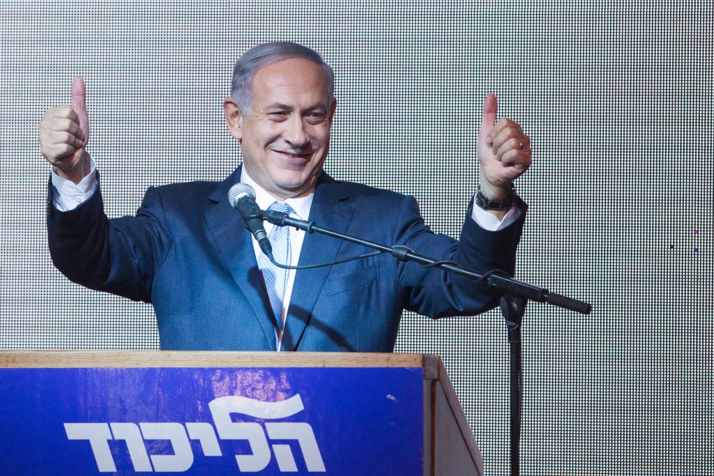 Benjamin Netanyahu gives the thumbs-up to supporters at the Likud party headquarters in Tel Aviv, early on March 18, 2015, hours after the TV exit polls were announced for the previous day's elections were published. (photo credit: Miriam Alster/Flash90)
