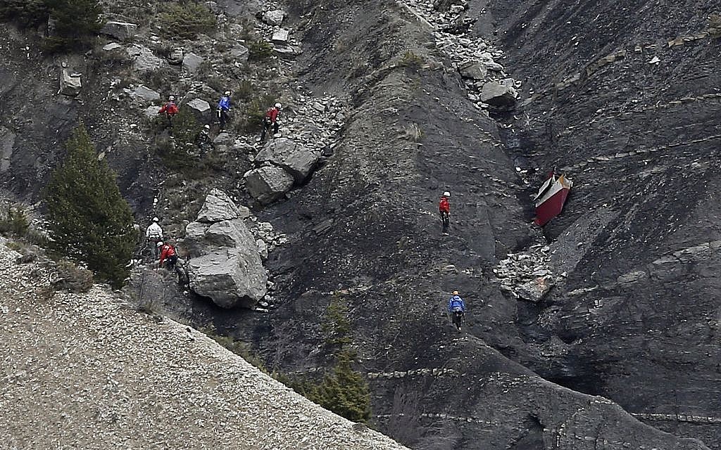Rescue workers work on debris at the plane crash site near Seyne-les-Alpes, France, Wednesday, March 25, 2015, after a Germanwings jetliner crashed Tuesday in the French Alps. (photo credit: AP/Laurent Cipriani)